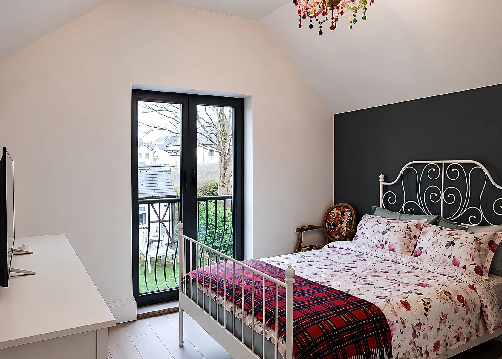 Sutton: A roof-level bedroom with a glazed door and balcony rail.